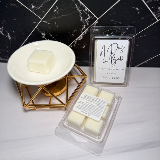 Two packages of wax melts labeled 'A Day in Bali' on a marble surface with a candle in the background.