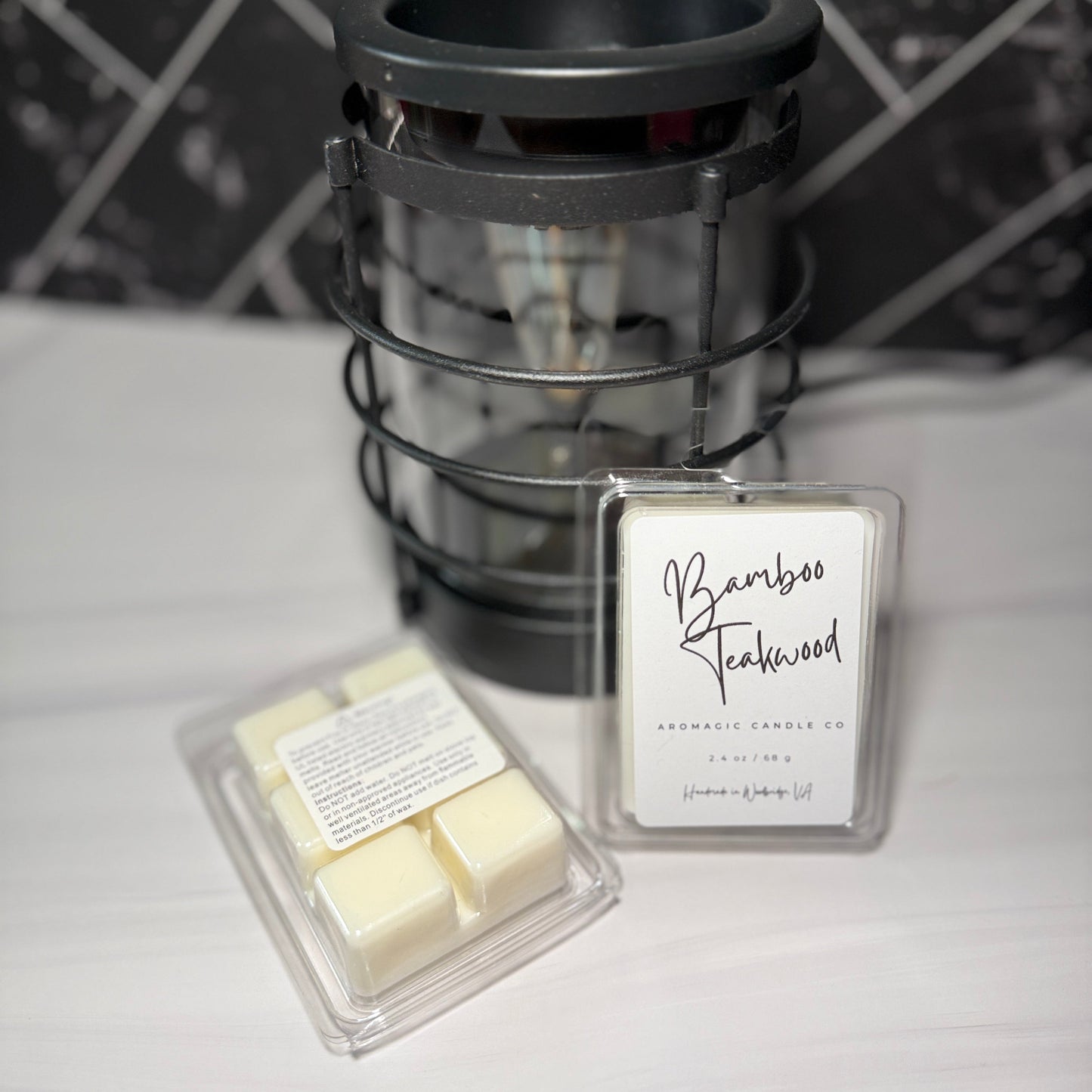 Bamboo Smokewood wax melts with packaging on a white surface with a tiled wall background