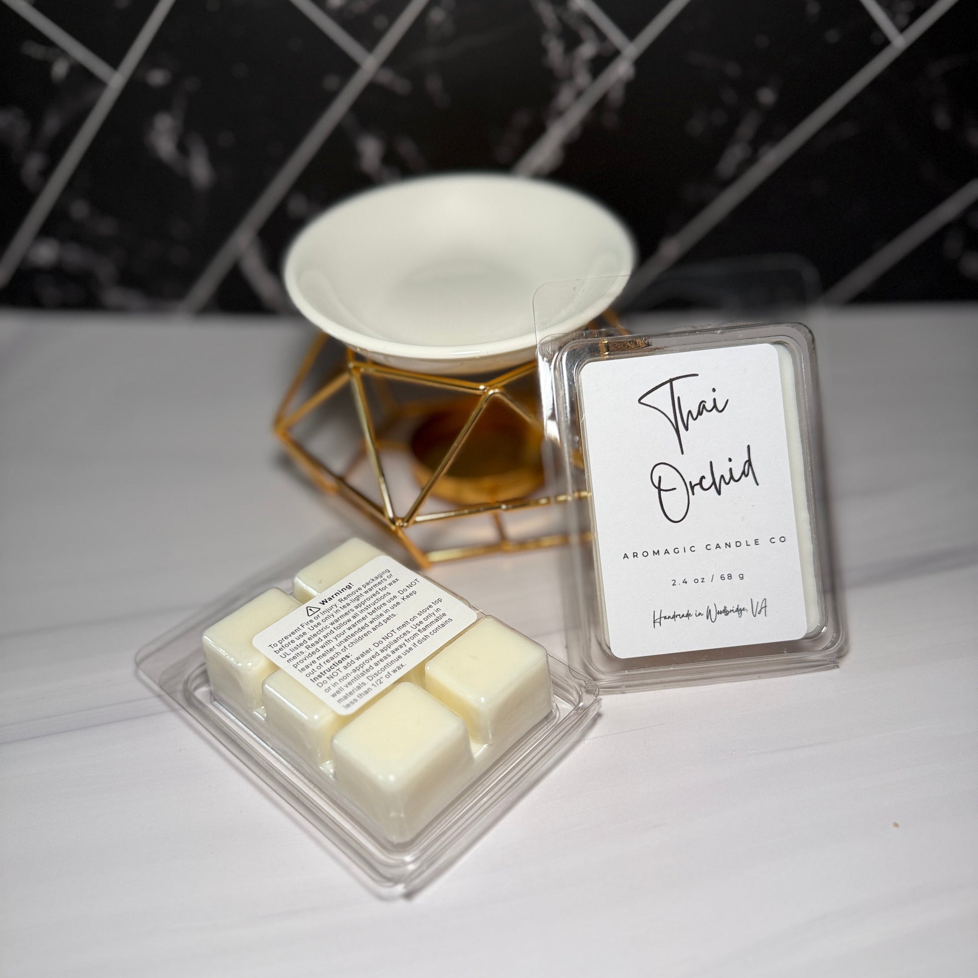 Two wax melts in packaging with a label on a white surface.