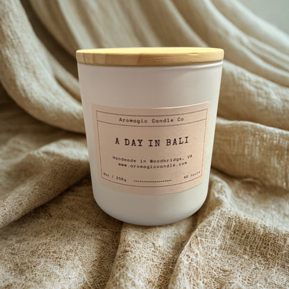 Candle labeled 'A Day in Bali' from Aromagic Candle Co. on a textured fabric background