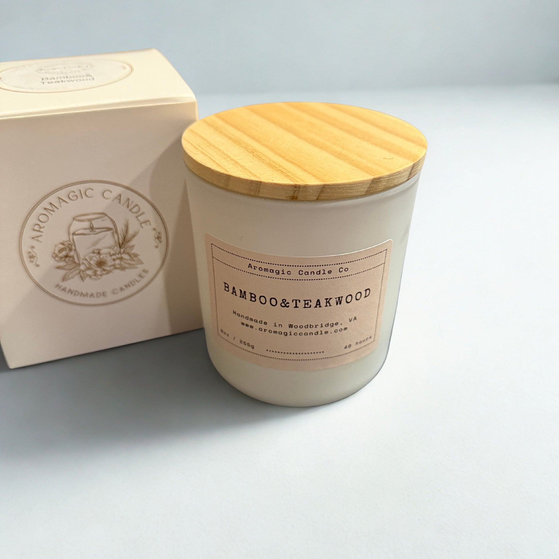 Candle with wooden lid and packaging on a light gray background